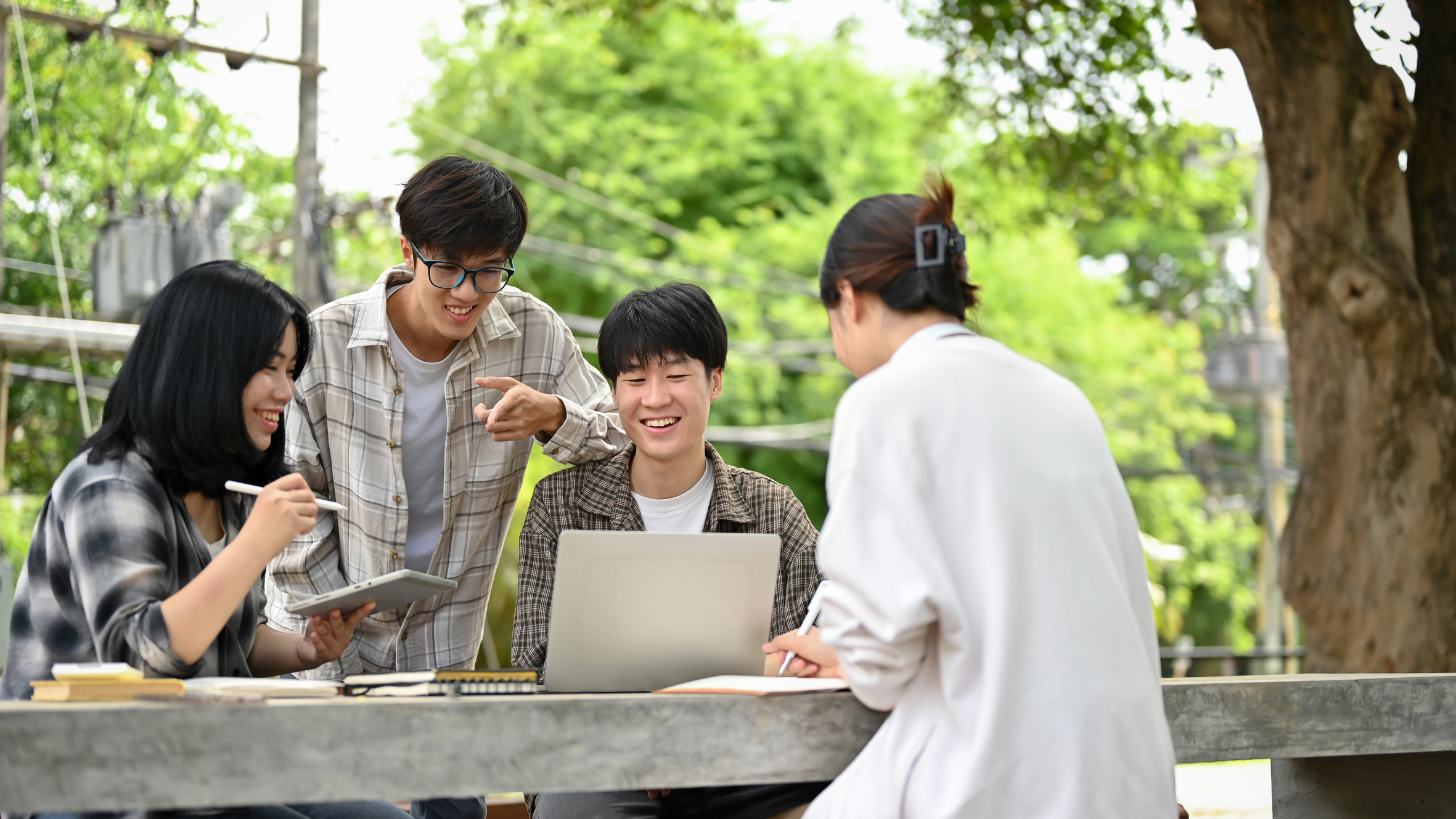 A group of happy Asian college students enjoy talking or sharing ideas on their project